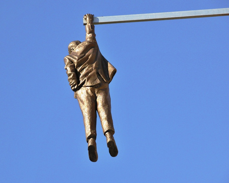 The Statue of a Man hanging by one hand - The suspended man